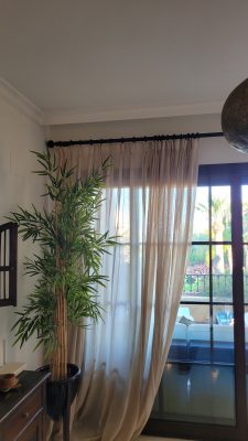 triple pinch pleat curtains draping onto the floor in the living room